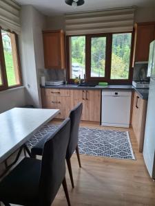 a kitchen with a table and chairs and windows at Simal Apart Ev in Ayder Yaylasi