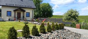 a small house with a garden in front of it at Letnisko domek z Sauną i Balią in Lubawka