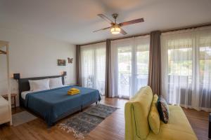 a bedroom with a bed and a couch and a fan at Boutique Hotel Peperpot in Meerzorg +76 photos