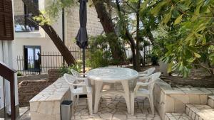a table and chairs with an umbrella on a patio at Apartment Botanicheskiy Sad in Sutomore