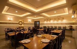 a restaurant with wooden tables and chairs in a room at HOTEL DAKHA INTERNATIONAL - Karol Bagh, New Delhi in New Delhi