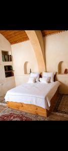 a bedroom with a bed with white sheets and pillows at Dar ennoul in Houmt Souk +14 photos