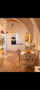 a kitchen with a table and chairs and a kitchen with an archway at Dar ennoul in Houmt Souk