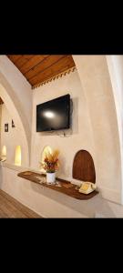 a room with a tv on a wall with a table at Dar ennoul in Houmt Souk