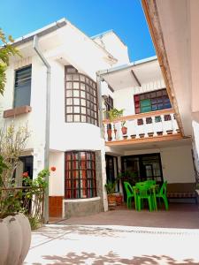 a white house with a green table and chairs at Spanish Friends in Sucre