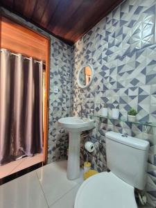 a bathroom with a toilet and a sink at Luz Residence suíte in Cabo Frio +17 photos