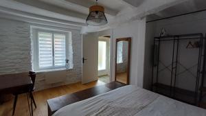 a bedroom with a bed and a desk and a window at Pont Menou Bretagne in Plouégat-Guérand