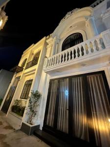 a white building with a balcony and a door at Vinh House Homestay in Thôn Trường Giang