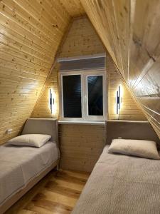 two beds in a room with a window at Tosor Medet A-frame in Tossor