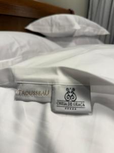 a white bed with a sticker on the side of it at Apartamento Boutique Cheia de Graça 304 in Divinópolis