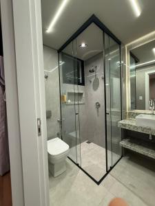 a bathroom with a shower and a toilet and a sink at Apartamento Boutique Cheia de Graça 304 in Divinópolis