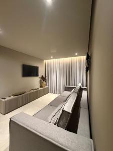 a room with a row of beds and a television at Apartamento Boutique Cheia de Graça 304 in Divinópolis