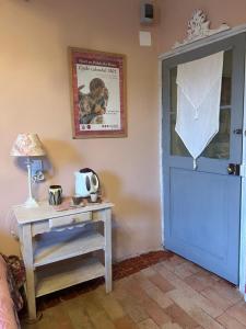 a room with a blue door and a table with a lamp at Chambre in Riez