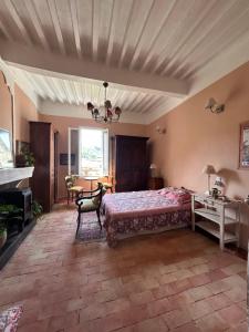 a bedroom with a bed and a table and a window at Chambre in Riez
