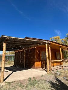 an old log cabin in the middle of a field at Cabañas bola 8 in Barreal