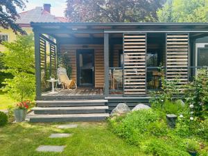 a small cabin with a deck with a table and a chair at Garden Lodge Obervellach in Obervellach
