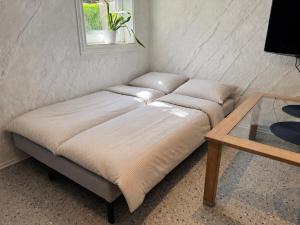 a couch in a corner with a table and a window at Pool & Sauna Retreat - Private Studio Apartment Porsgrunn in Porsgrunn