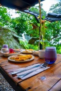 a wooden table with plates of food on it at Glamping Entre Rocas Tena in Tena