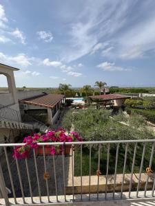 a balcony of a house with pink flowers on it at Le Zarafe in Caltabellotta