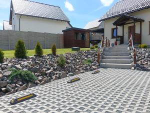 a house with a stone walkway in front of a yard at Letnisko domek z Sauną i Balią in Lubawka