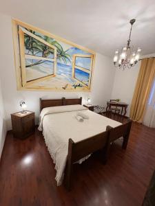 a bedroom with a bed with a painting on the wall at Le Zarafe in Caltabellotta