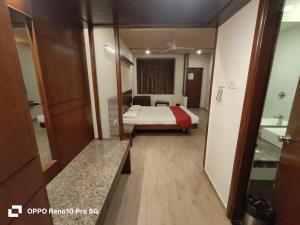 a hotel room with a bed and a bathroom at Hotel Ikon in Hubli