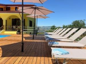 a row of lounge chairs with umbrellas on a deck at Relais Green Paradise in Apice