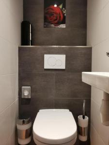 a bathroom with a white toilet and a red rose at Hotel Jesse in Amsterdam