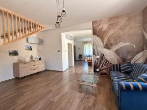 a living room with a blue couch and a staircase at Relais Green Paradise in Apice