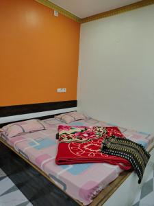 a bed with a blanket on it in a room at Ganesh Cottage in Matheran