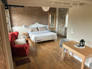 a bedroom with a bed and a table and a chair at A un passo dal Collio in Mossa