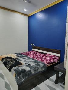 a bedroom with a bed with a blue wall at Ganesh Cottage in Matheran
