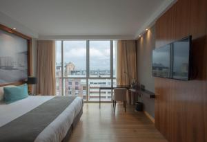 a hotel room with a bed and a large window at Puerto Norte Design Hotel in Rosario +29 photos