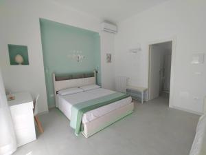 a bedroom with a bed in a white room at Le Cromie di Amelie in Ceglie Messapica