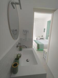 a bathroom with a sink and a bed and a mirror at Le Cromie di Amelie in Ceglie Messapica