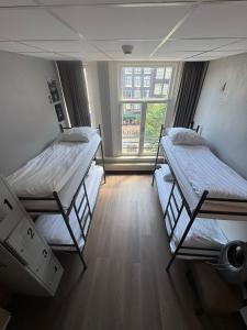 two bunk beds in a room with a window at Hotel Jesse in Amsterdam