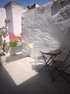 a table and chairs on a balcony with a wall at Apartamentos Teresita in Badajoz