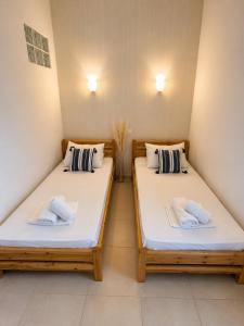 two beds in a room with white sheets and pillows at Beachfront Paradise in Leptokarya