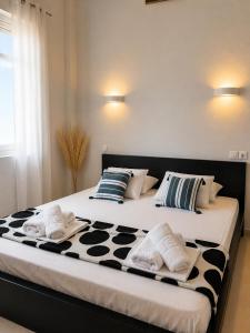 a large bed with black and white pillows on it at Beachfront Paradise in Leptokarya