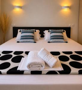 a bed with two towels and pillows on it at Beachfront Paradise in Leptokarya