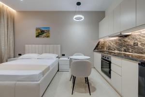 a bedroom with two beds and a table and a kitchen at Swimming Pool - Marko Studios Berat in Berat