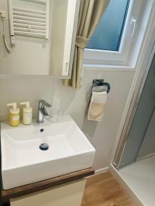 a bathroom with a white sink and a window at Garden Lodge Obervellach in Obervellach +17 photos