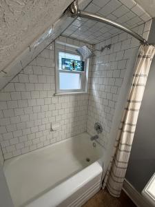 a white bathroom with a tub and a window at Barrel House on Derby Row in Louisville +28 photos