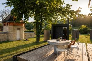 a wooden deck with a table and chairs in a yard at Sûr Jumigny in Jumigny