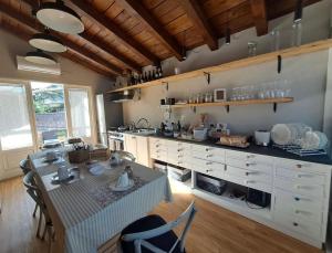 a large kitchen with a table and a counter top at A un passo dal Collio in Mossa