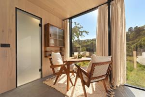 a room with a table and chairs and a large window at Sûr Jumigny in Jumigny