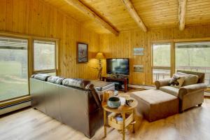 a living room with a couch and a tv at Mountain Views + BBQs: Updated Cody Cabin in Cody