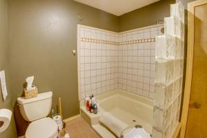 a bathroom with a toilet and a bath tub at Mountain Views + BBQs: Updated Cody Cabin in Cody +19 photos