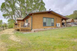 a log cabin with a porch on a grass field at Mountain Views + BBQs: Updated Cody Cabin in Cody