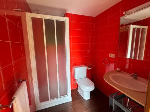 a red bathroom with a toilet and a sink at Casa das Minas in Zobra